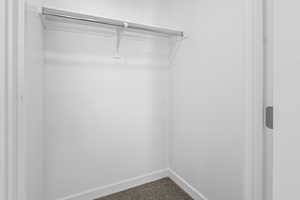 Walk in closet featuring dark carpet