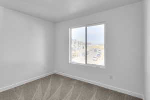 Carpeted spare room with baseboards