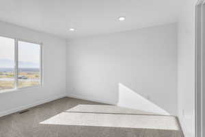 Empty room with light colored carpet, a mountain view, and recessed lighting