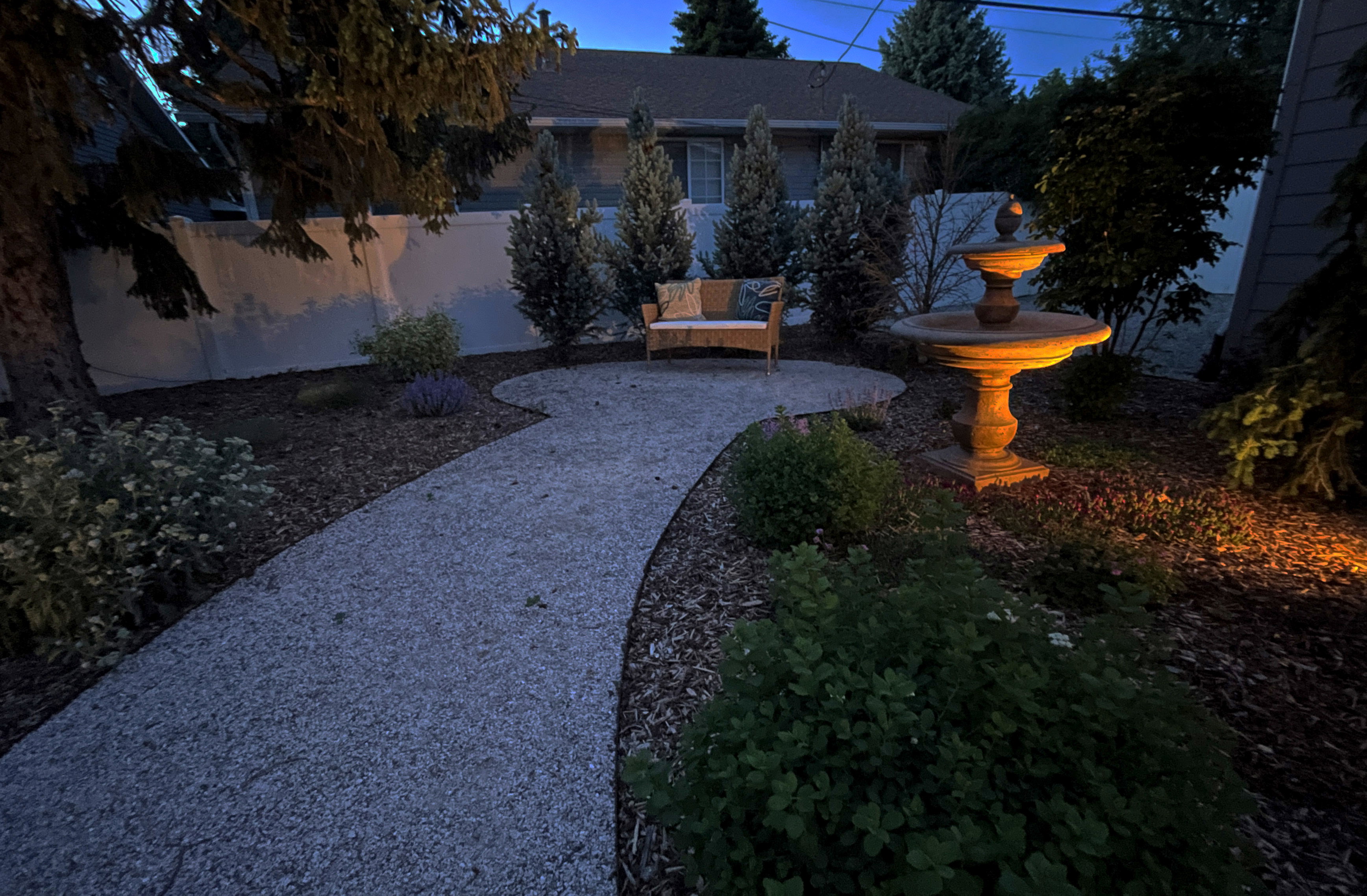 Curved gravel pathway leading to a two-tier fountain