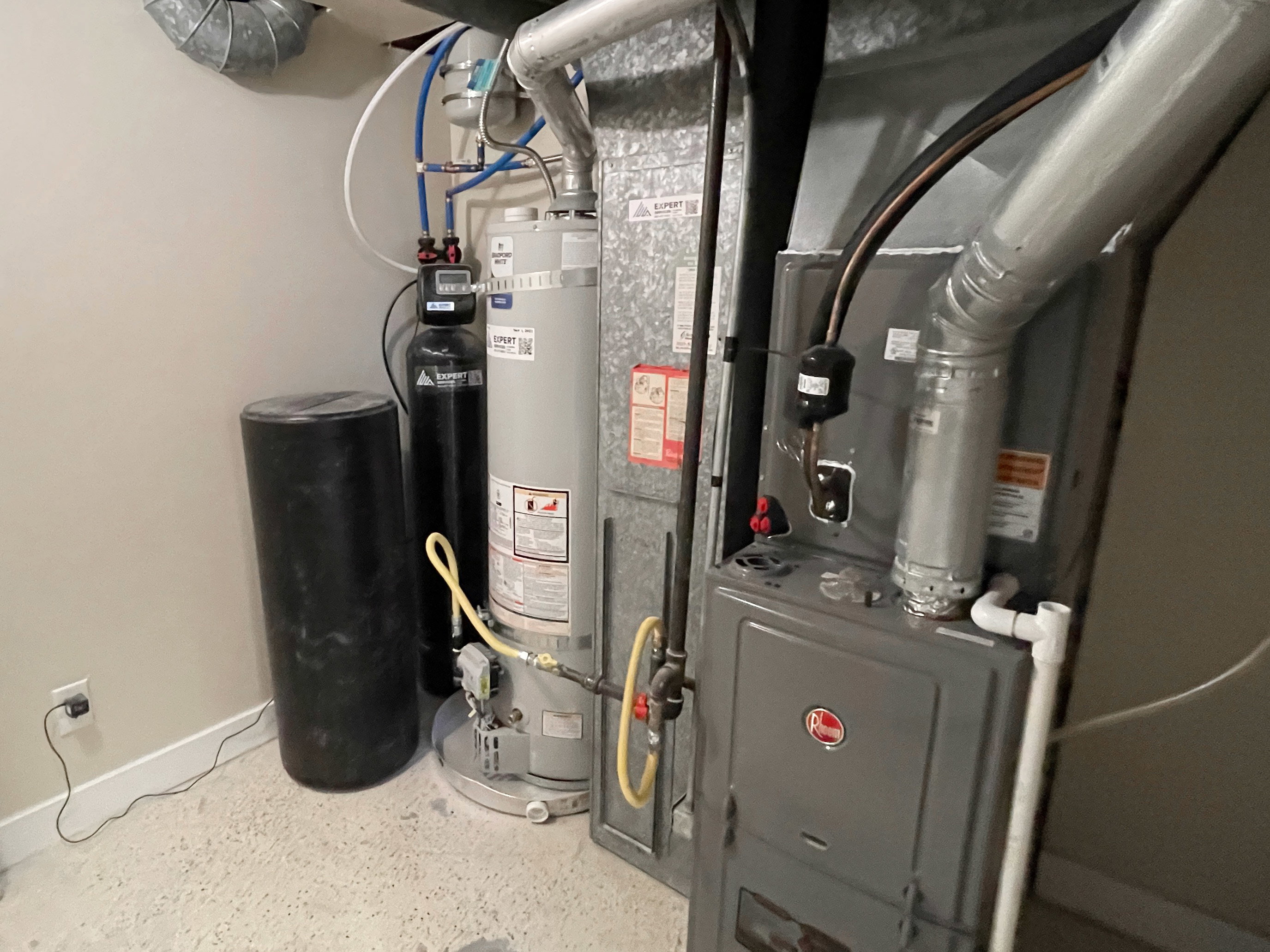 Dedicated utility space featuring a water heater, furnace, and water softener system
