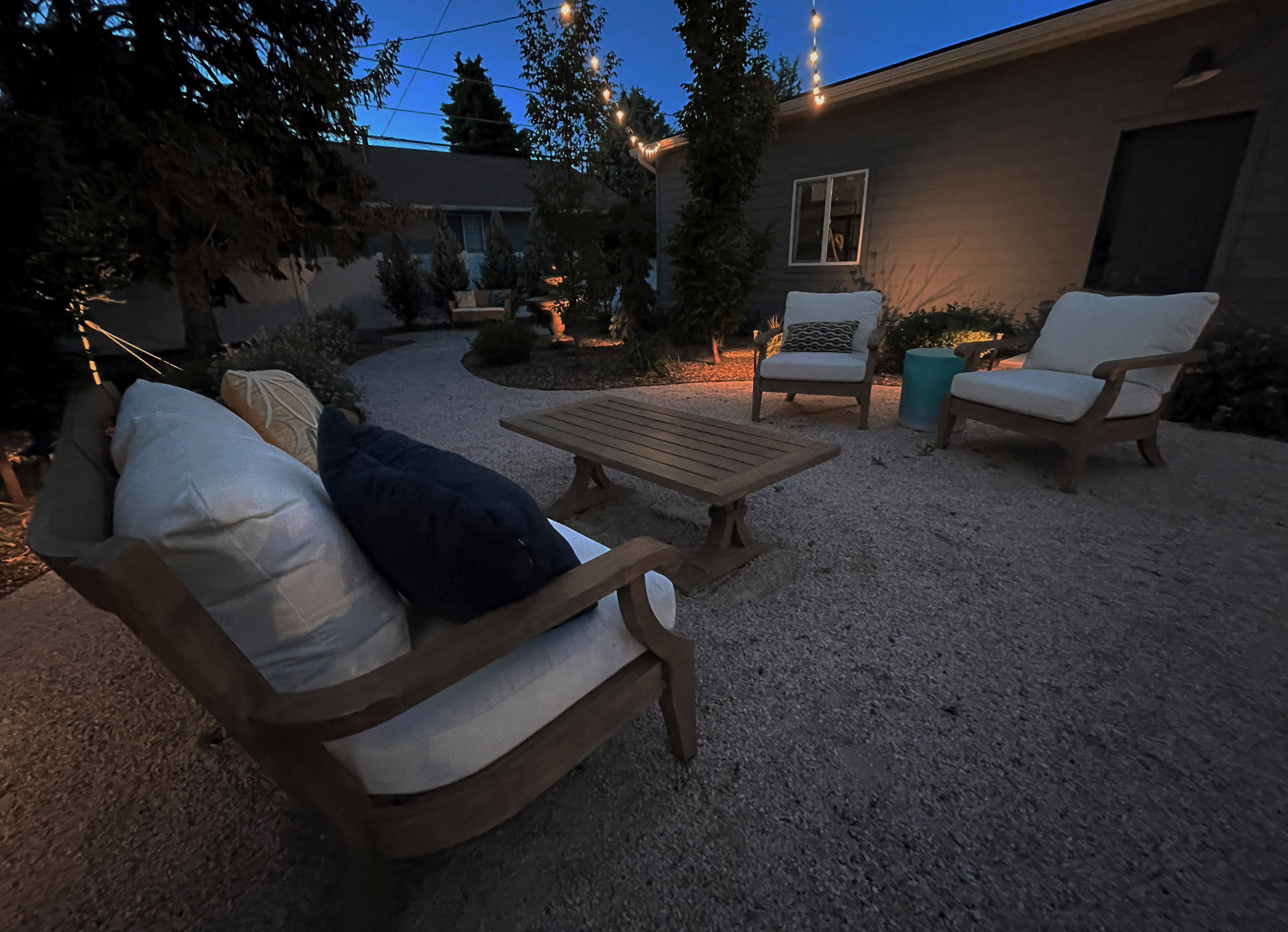 Expansive gravel patio with string lighting and accent landscaping