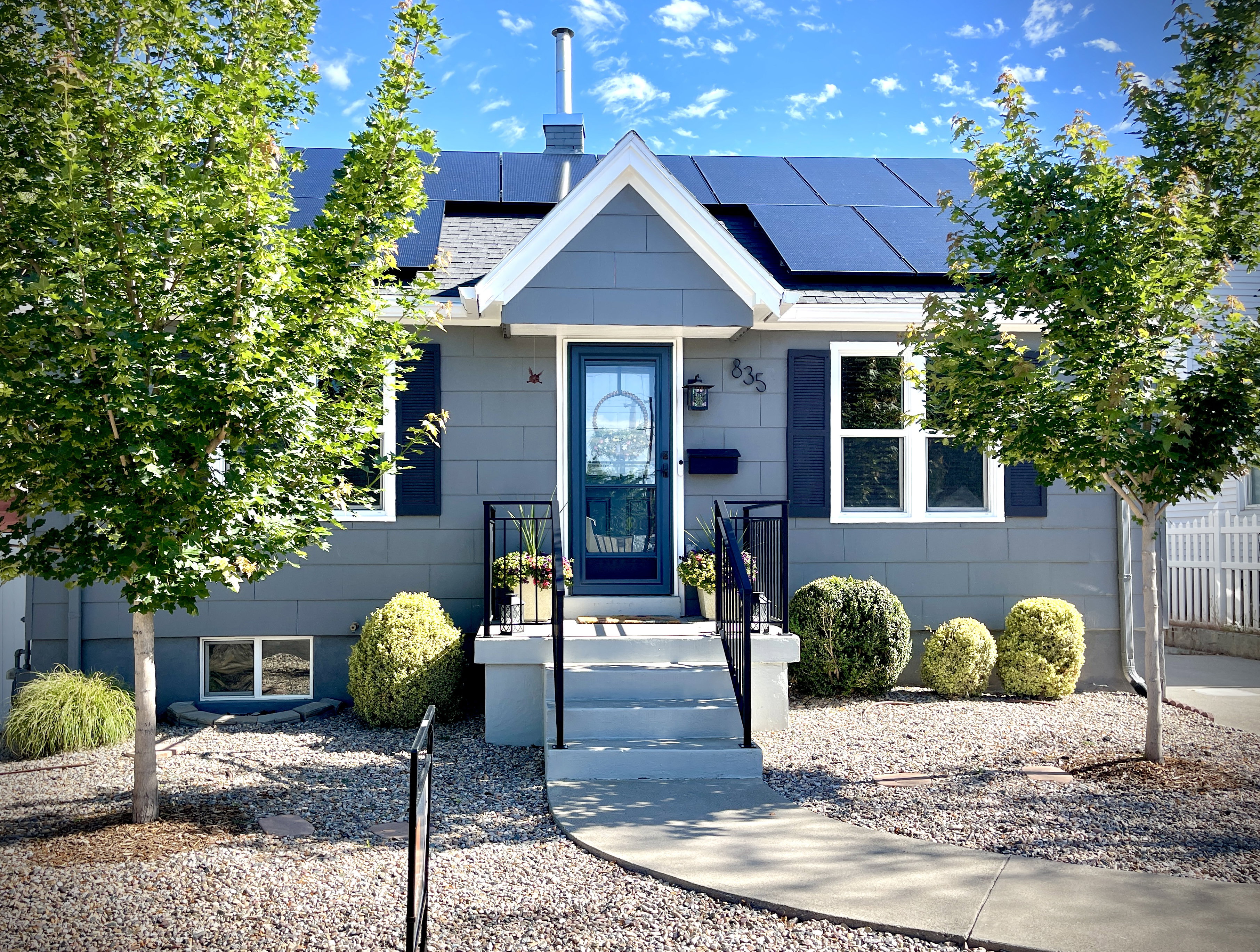 Charming residential exterior featuring grey siding and a prominent front gable