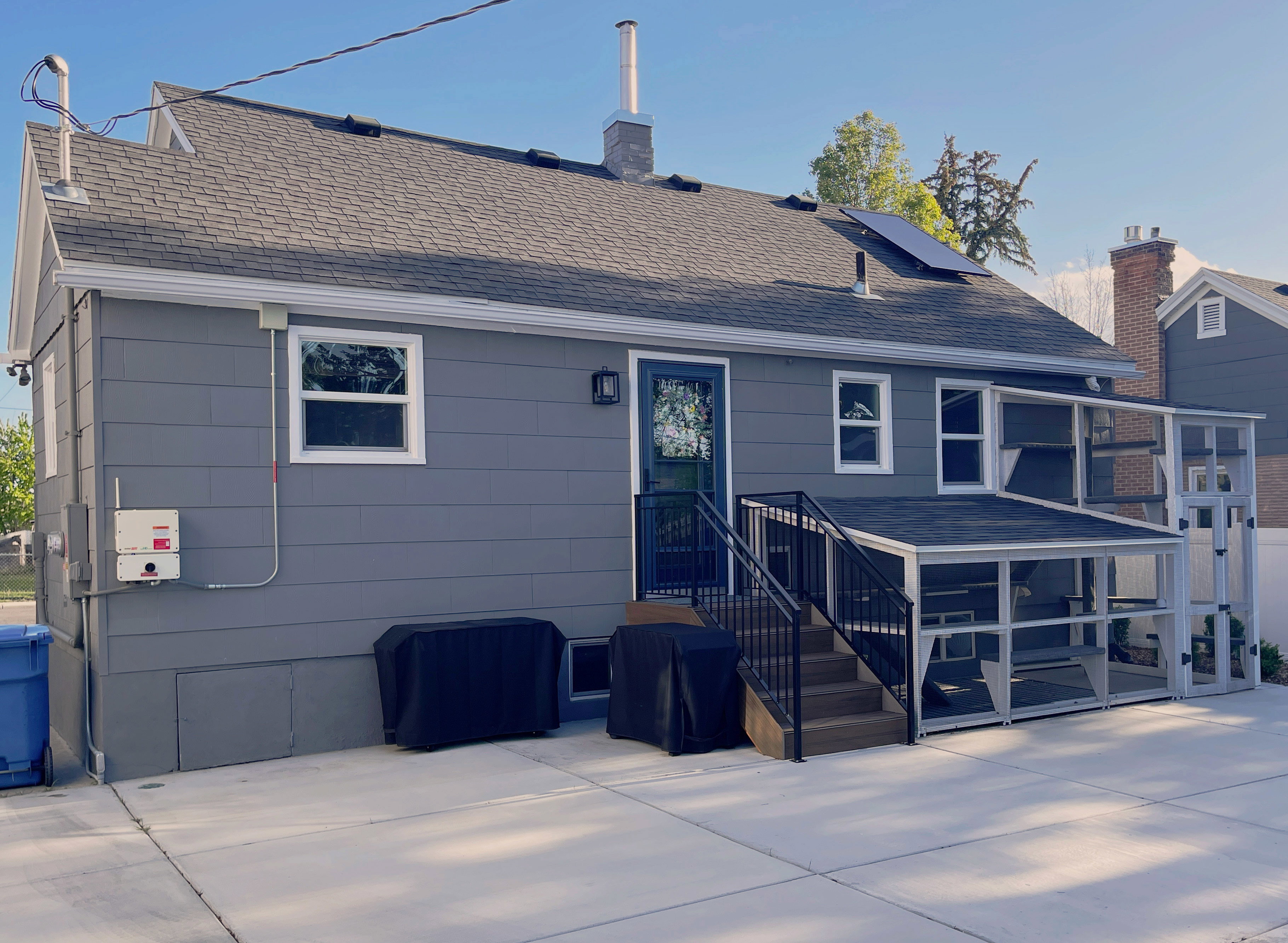 Gray siding exterior with a dark shingle roof and white trim