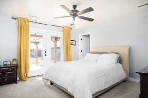 Carpeted bedroom featuring access to exterior, ceiling fan, and french doors