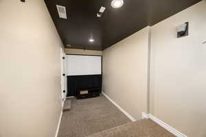 Home theater room featuring dark colored carpet and recessed lighting