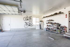Garage with freestanding refrigerator and a garage door opener