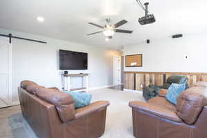 Living room featuring a barn door and ceiling fan