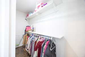 Walk in closet featuring dark wood finished floors