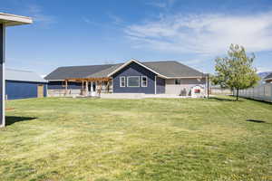 Rear view of house featuring a fenced backyard, a shingled roof, a patio area, and a pergola