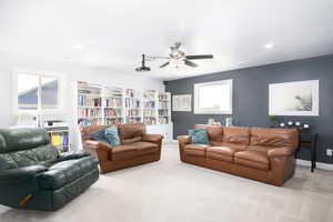 Carpeted living room with a ceiling fan and recessed lighting