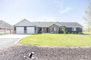View of front of property with concrete driveway, stone siding, board and batten siding, and a garage