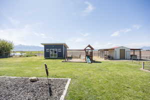 View of yard with a mountain view, a playground, and a shed