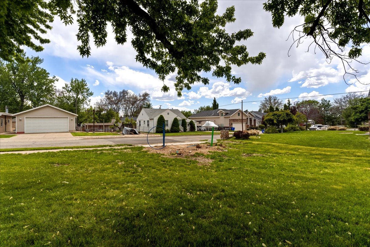 View of green lawn featuring a detached garage