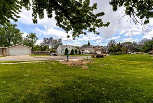 View of green lawn featuring a detached garage