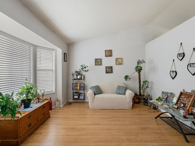 Sitting room with light wood-type flooring and lofted ceiling
