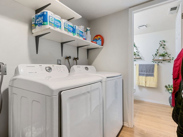 Laundry room featuring light wood-style floors and independent washer and dryer