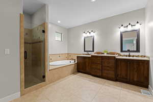 Full bath with double vanity, a shower stall, a garden tub, light tile patterned flooring, and recessed lighting