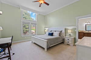 Bedroom with light carpet, ornamental molding, a ceiling fan, ensuite bath, and an office area