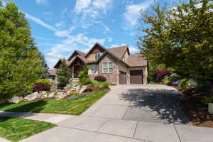 Craftsman inspired home with stone siding, driveway, a garage, and stucco siding