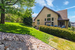 Rear view of property featuring stucco siding and a yard