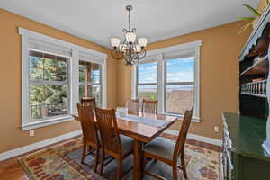 Dining area with wood finished floors and suspended lighting