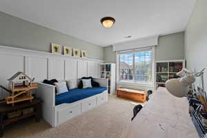 Carpeted bedroom with a decorative wall