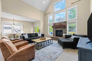 Living room with vaulted ceiling and a stone fireplace