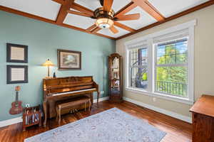 Living area featuring coffered ceiling, wood-type flooring, and ceiling fan
