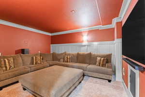 Living room with light colored carpet, a decorative wall, and wainscoting