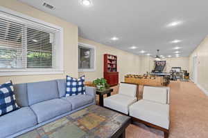 Carpeted living area with recessed lighting and baseboards