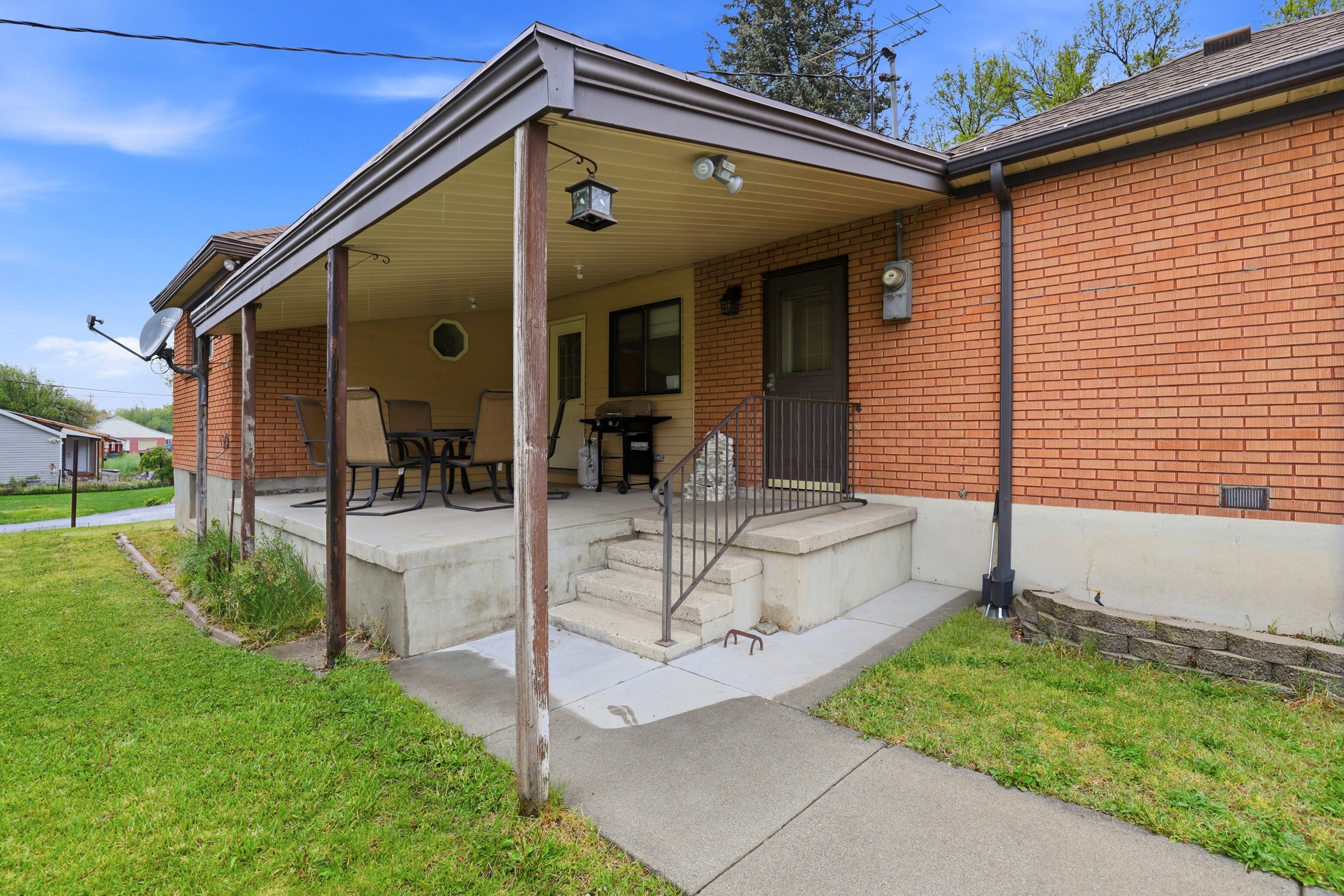 View of front of house featuring covered porch, brick siding, and a front yard
