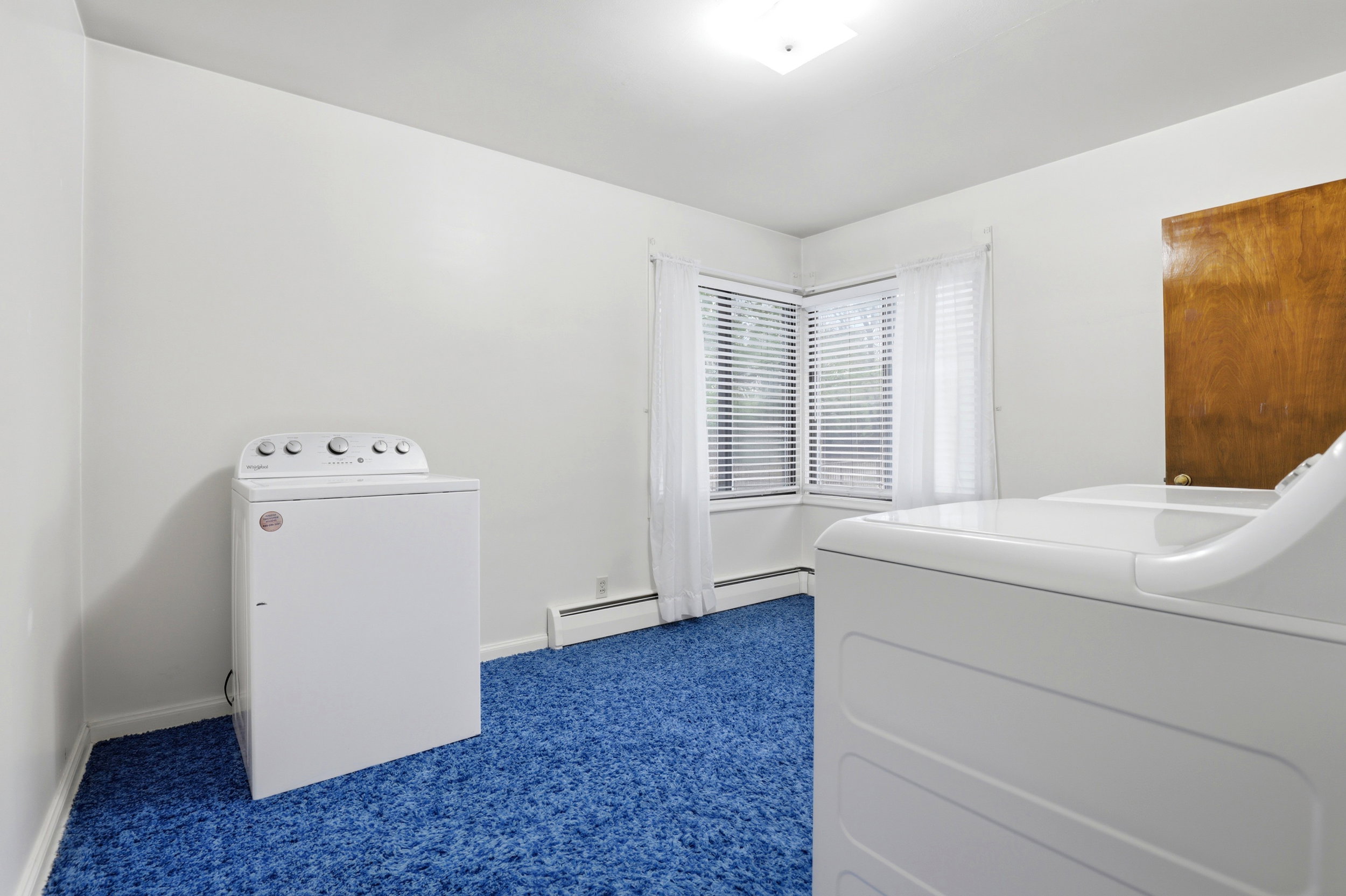 Bedroom with dark colored carpet and washing machine and clothes dryer