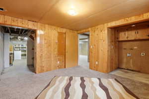 Unfurnished bedroom with wood walls and washer / dryer