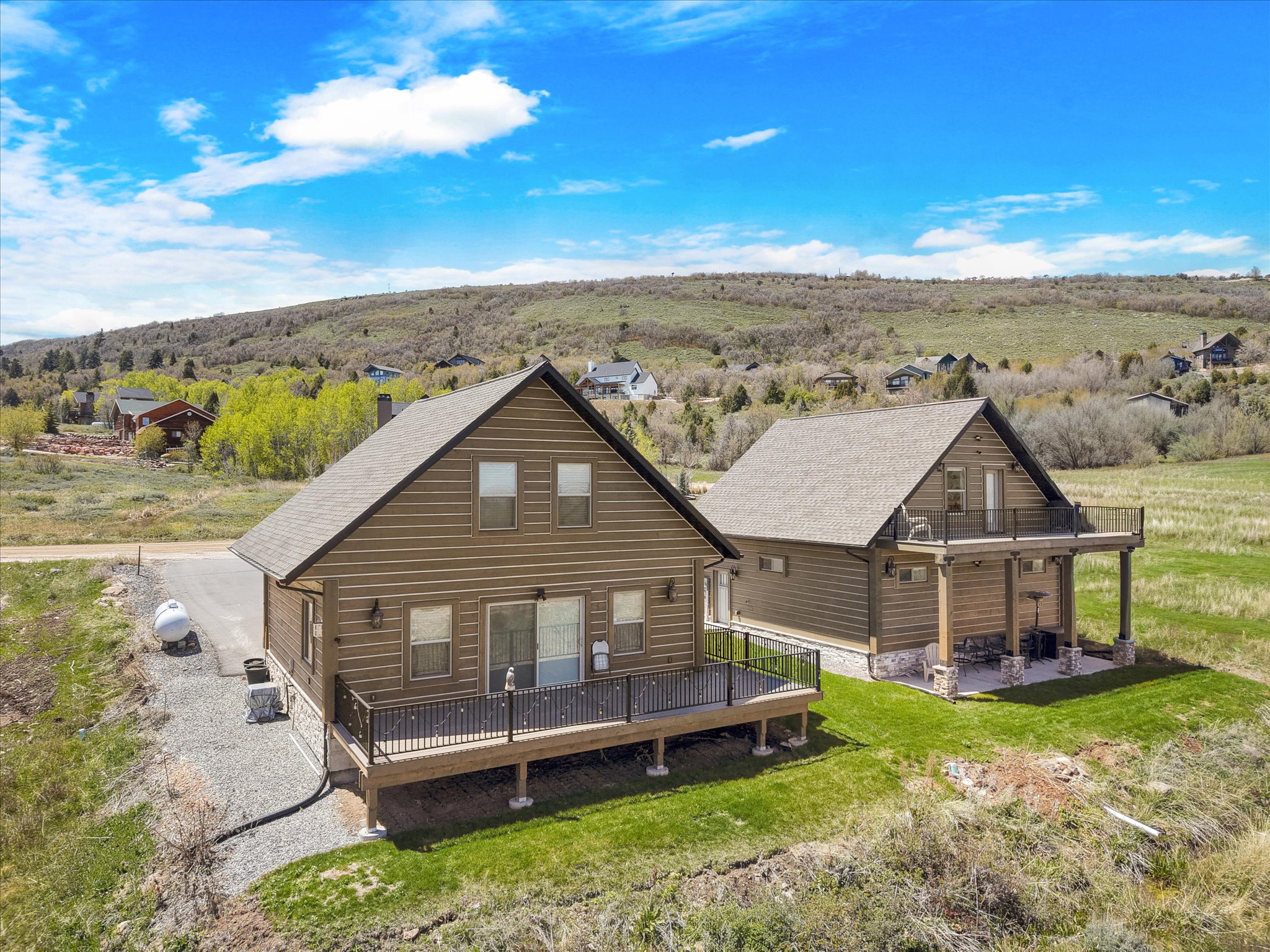 Two rustic-style homes with pitched roofs and wood-paneled siding