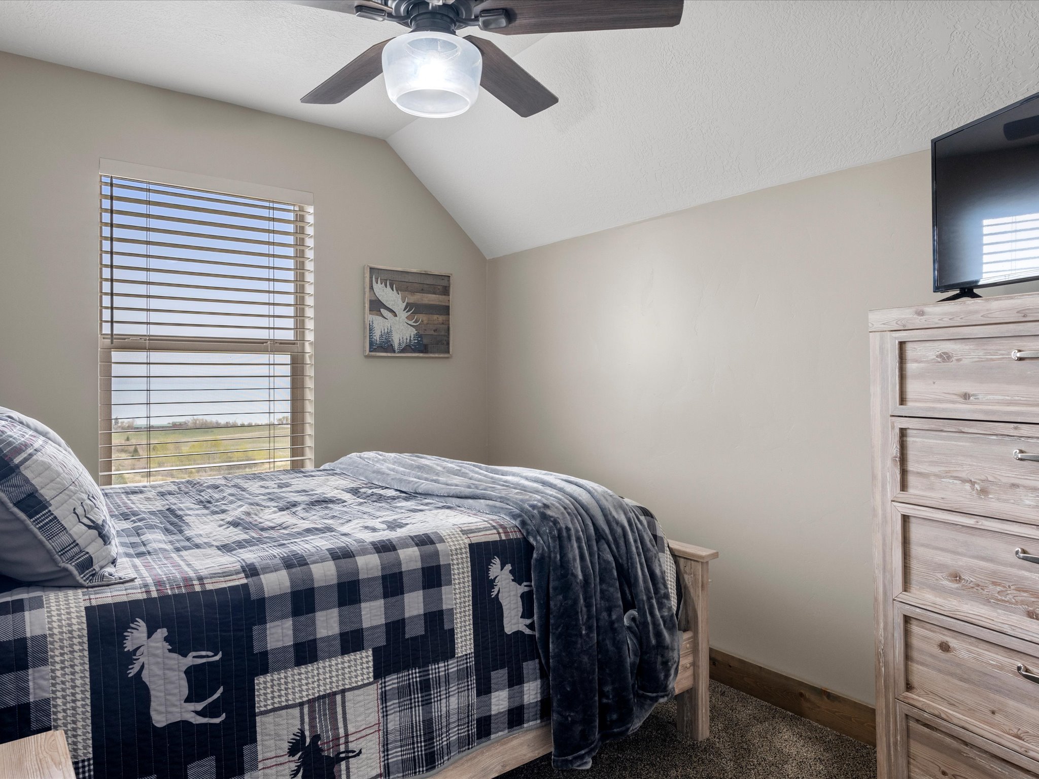 Bedroom featuring ceiling fan and dark colored carpet