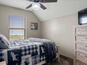 Bedroom featuring ceiling fan and dark colored carpet