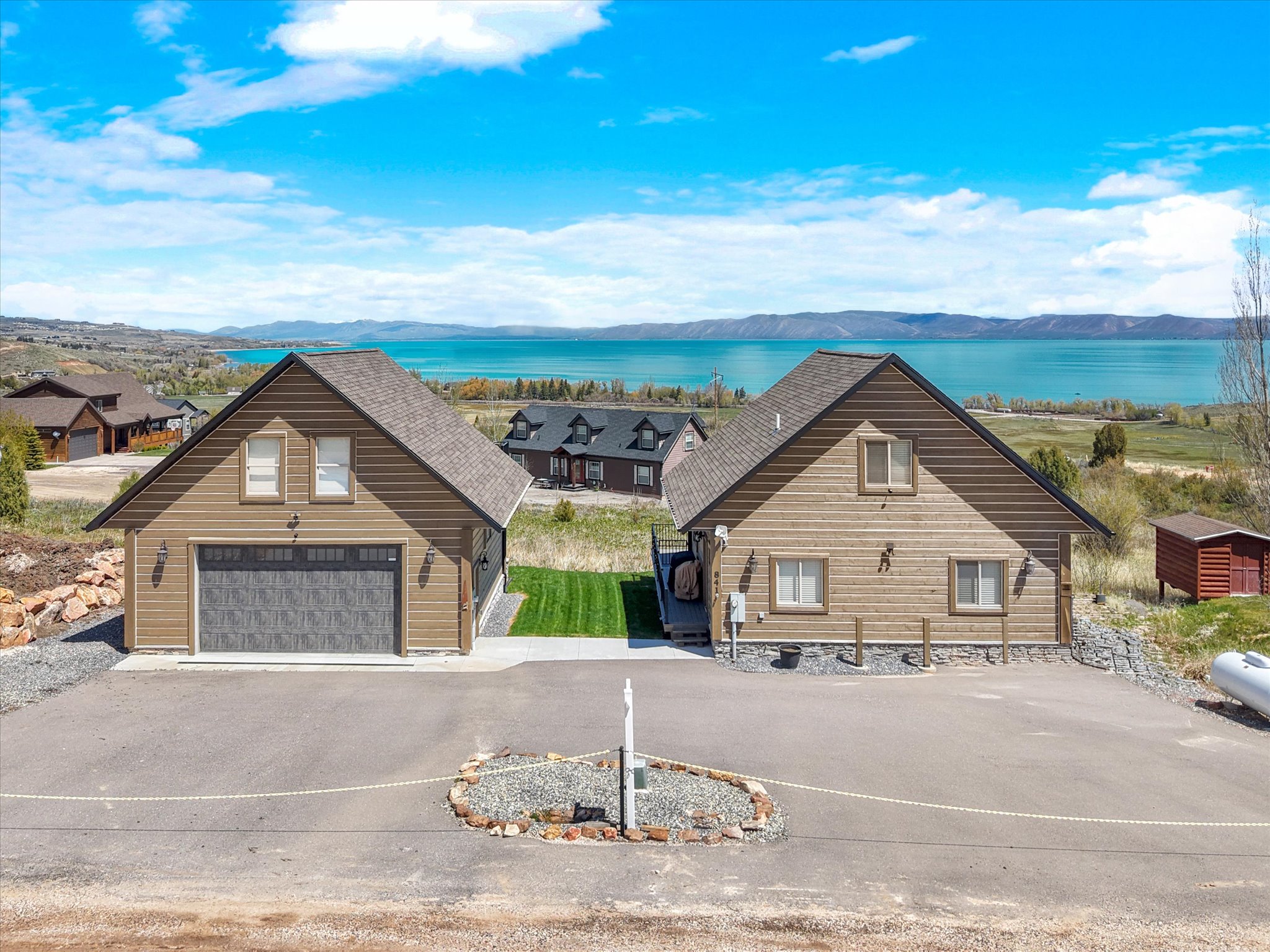 Two distinct structures featuring wood siding and asphalt shingle roofs