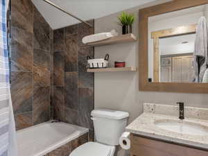 Full bathroom with tiled shower / bath and vanity