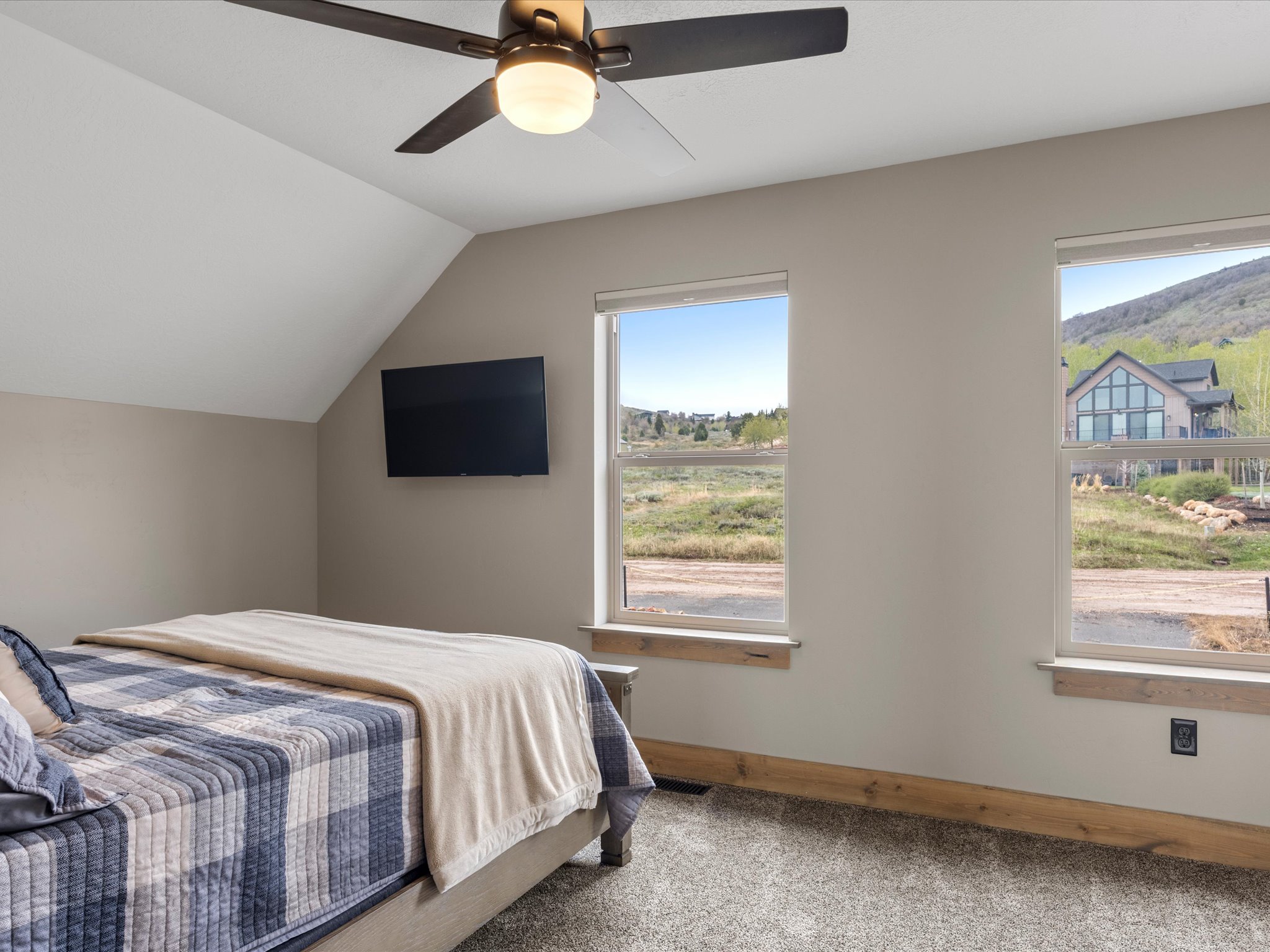 Bedroom featuring light carpet, lofted ceiling, and a ceiling fan