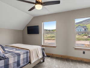 Bedroom featuring light carpet, lofted ceiling, and a ceiling fan