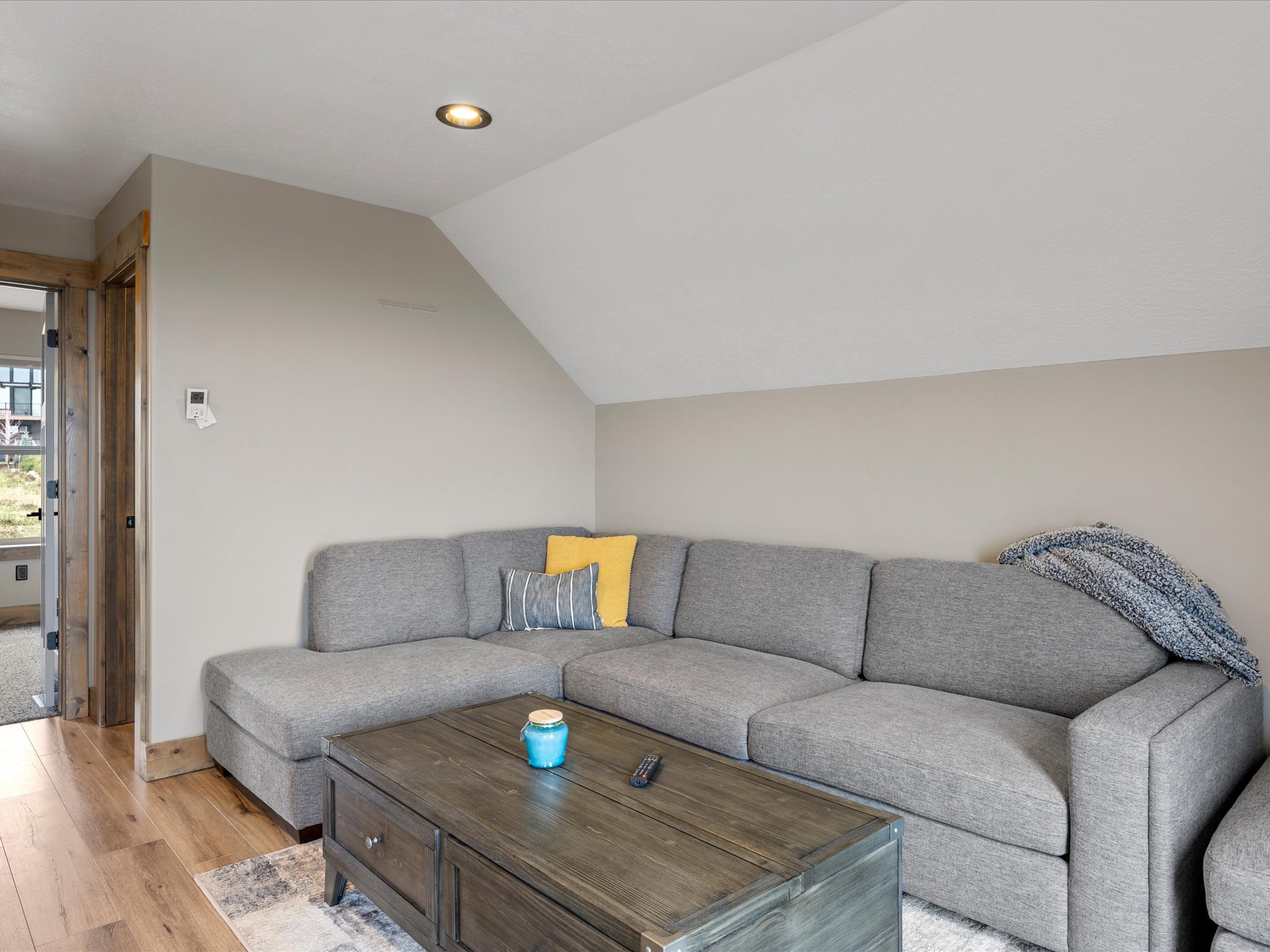 Living area featuring light wood finished floors and vaulted ceiling