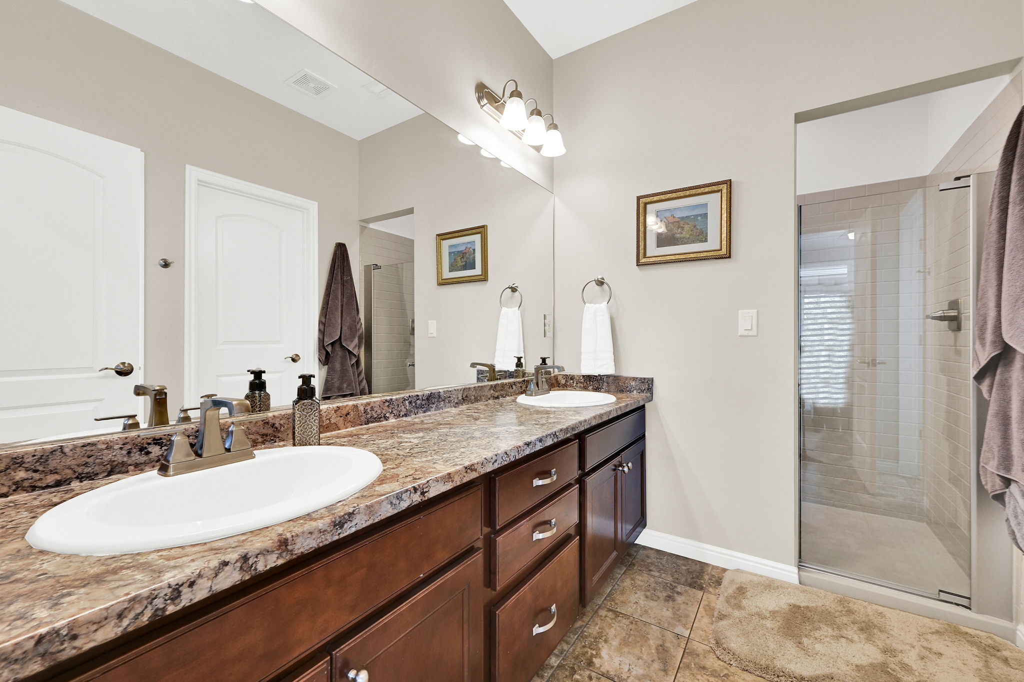 Primary bathroom with a shower stall, and double vanity.