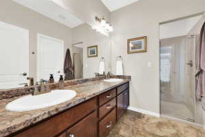 Primary bathroom with a shower stall, and double vanity.