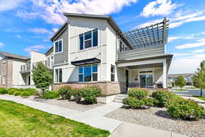 View of front of home featuring brick siding, a porch, stucco siding, and a front lawn area that opens to extra parking