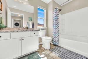 Full bath with vanity, shower / bath combo, and light tile patterned flooring