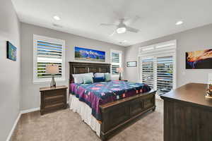 Main level Primary Suite featuring light carpet, ceiling fan, a textured ceiling, and recessed lighting showing the additional entrance from the porch/patio area