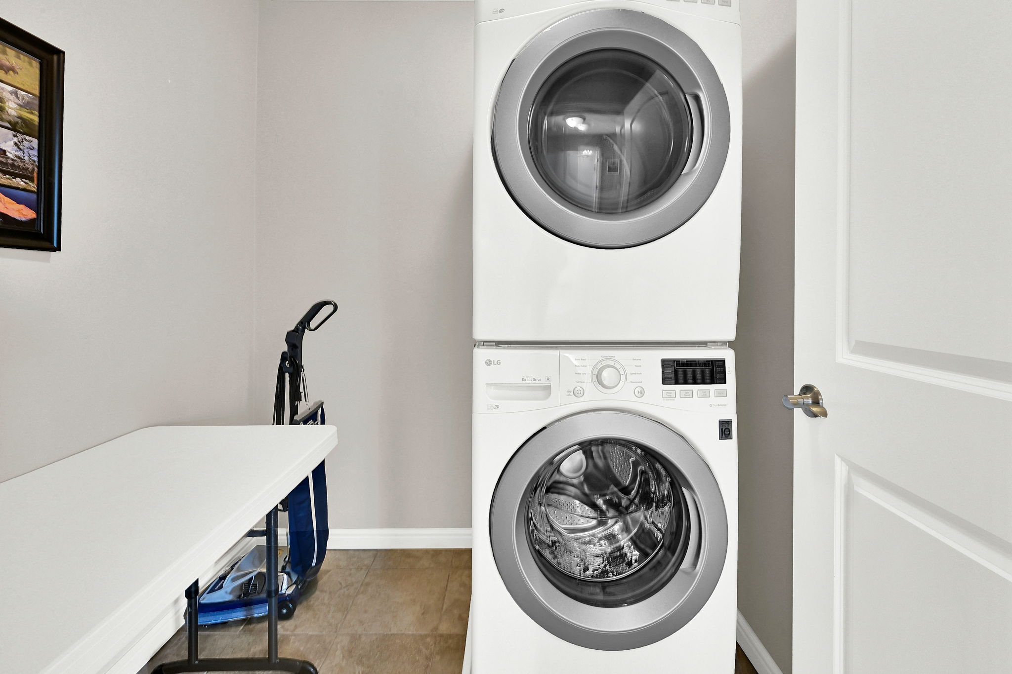 Laundry area with stacked washer / dryer and light tile patterned floors.  There is also a second location option for laundry on the 1st floor under the stairs.