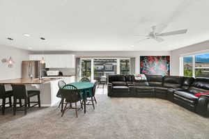 Living area featuring light carpet, healthy amount of natural light