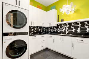 Laundry area featuring cabinet space and stacked washing machine and dryer